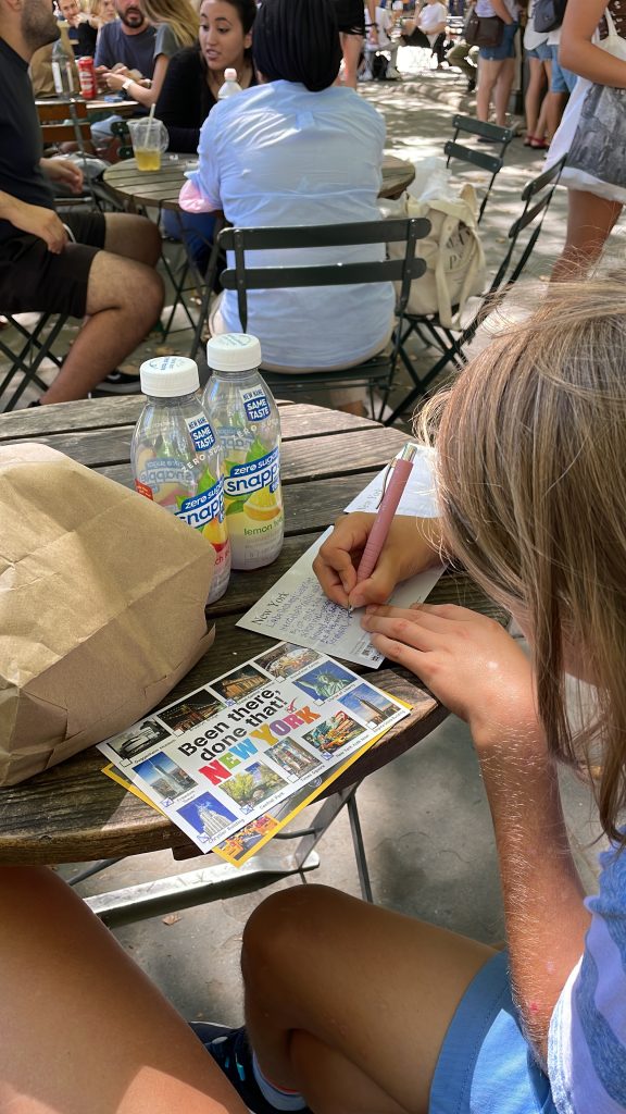 Ein Junge schreibt Postkarten von New York 
