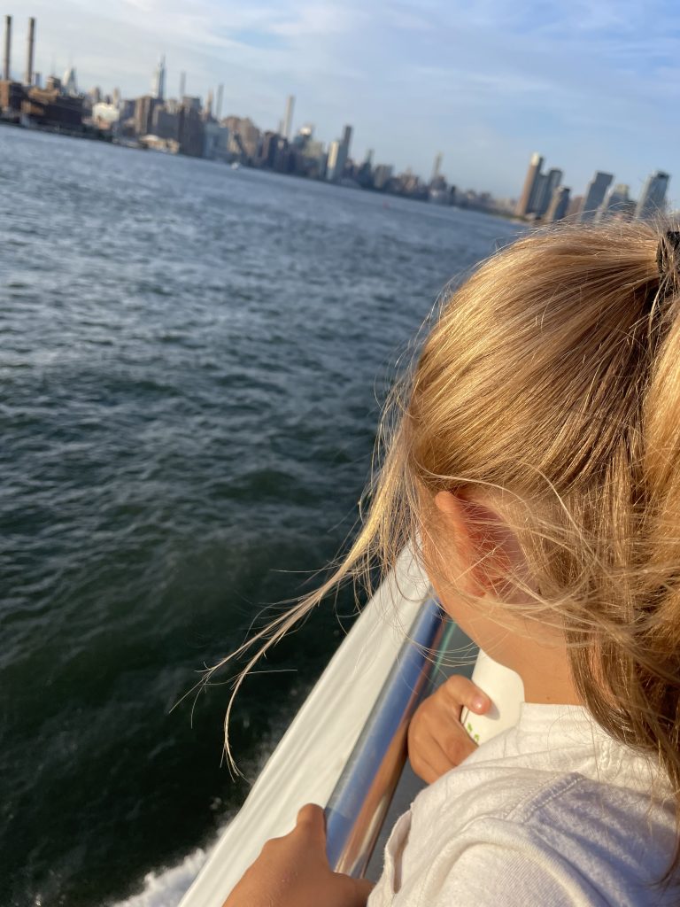 Ein Kind schaut aufs Wasser von einem Boot