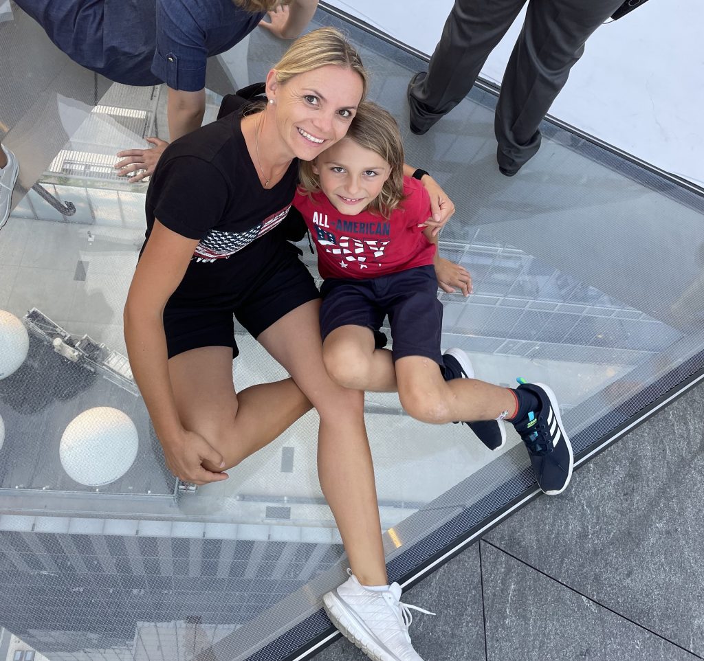 Eine Frau und ein Kind sitzen auf dem Boden eines Glasbalkons im 100. Stock des Hochhauses Edge in New York